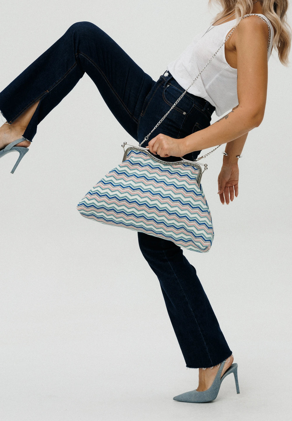 Woman holding a striped handbag against a white background