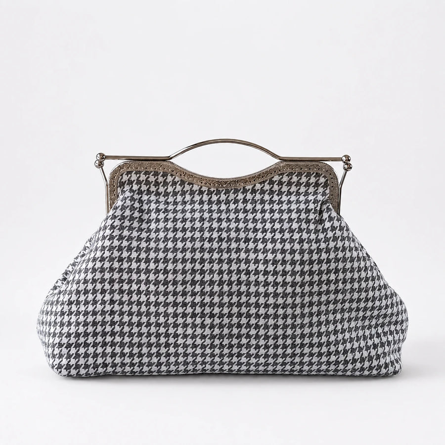 Houndstooth patterned handbag with a metal frame on a white background