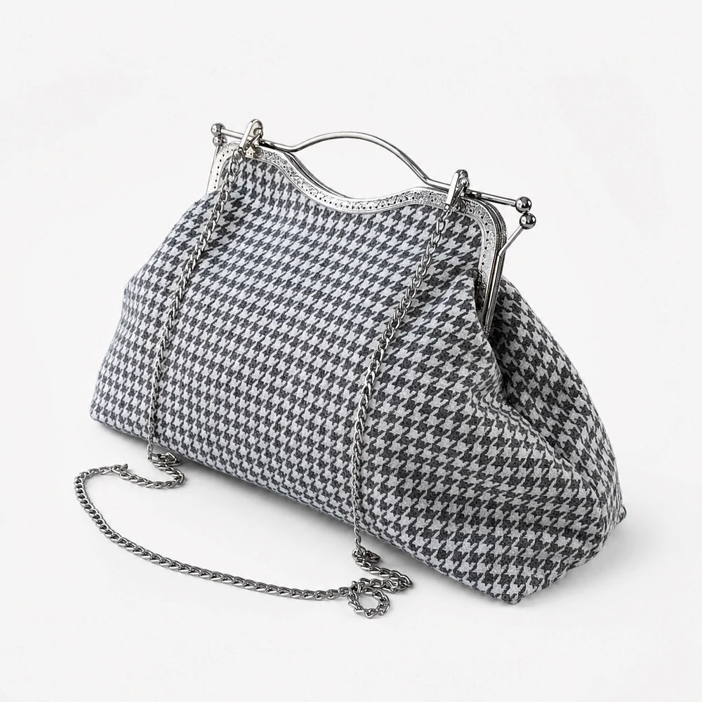 Houndstooth patterned handbag with metallic frame and chain strap on a white background