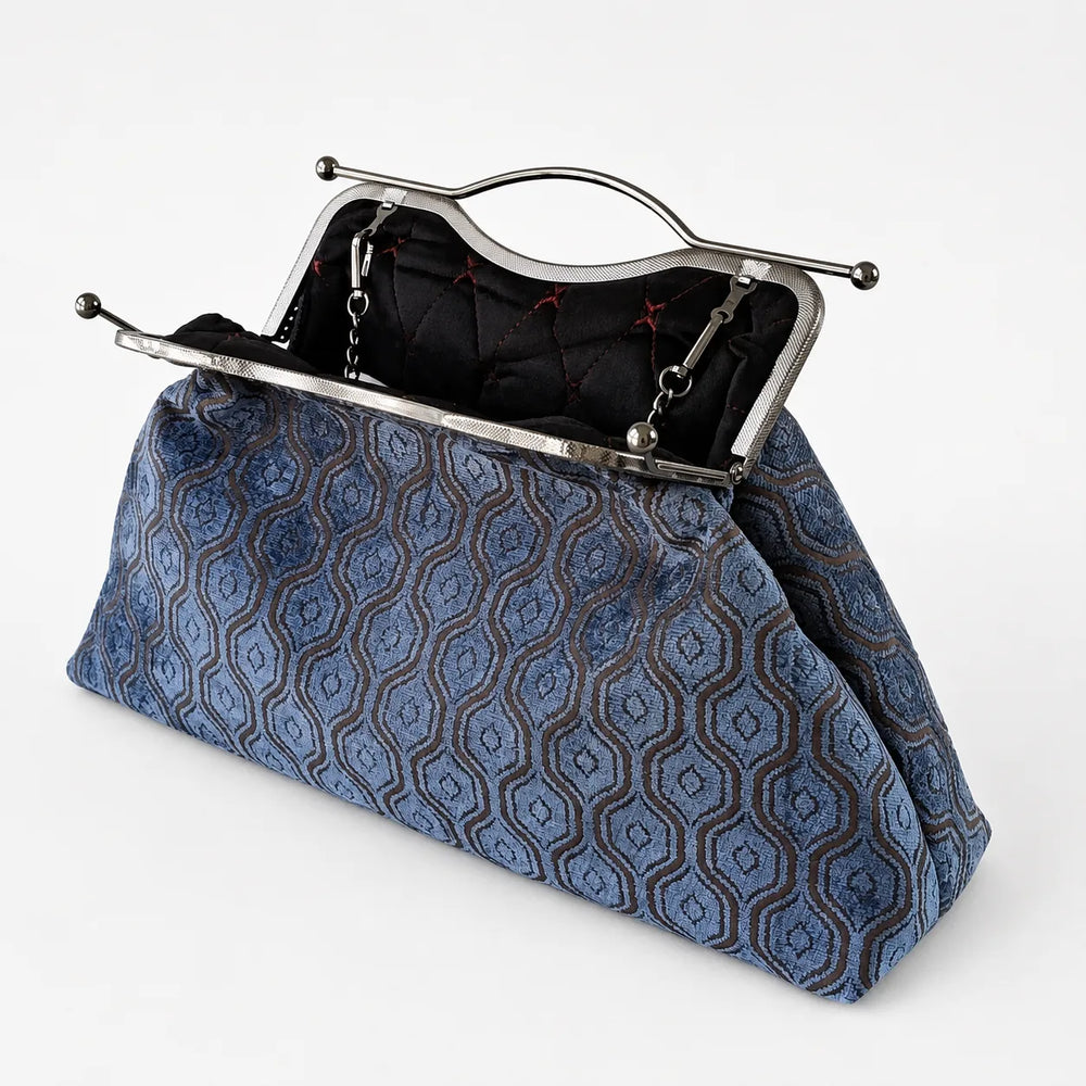 Blue patterned handbag with a silver frame on a white background