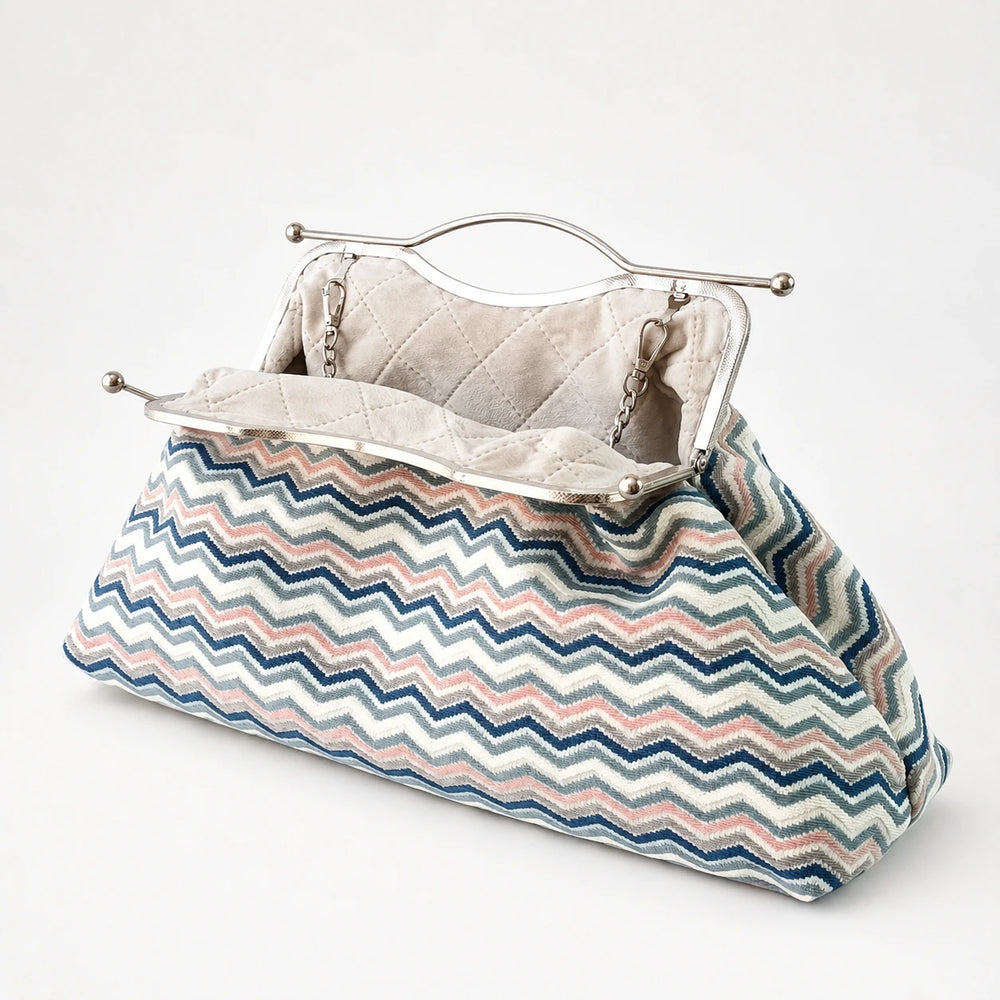 Clutch bag with zigzag pattern and metallic frame on a white background