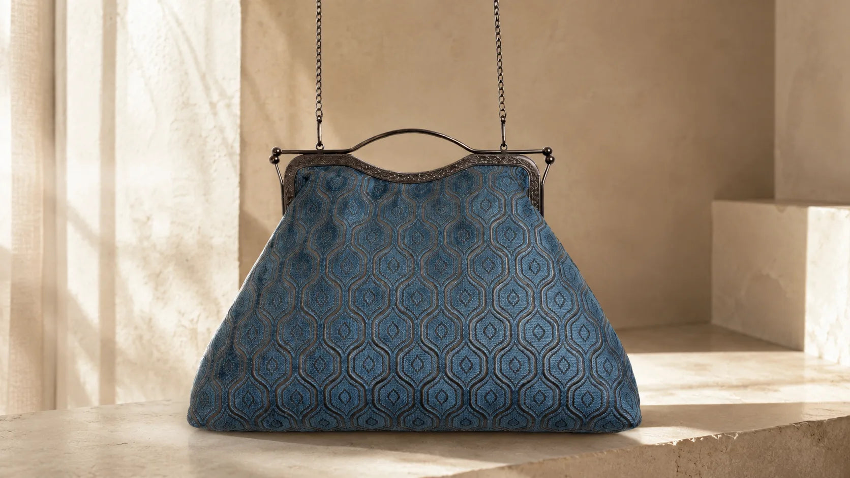 Blue patterned handbag hanging against a beige wall