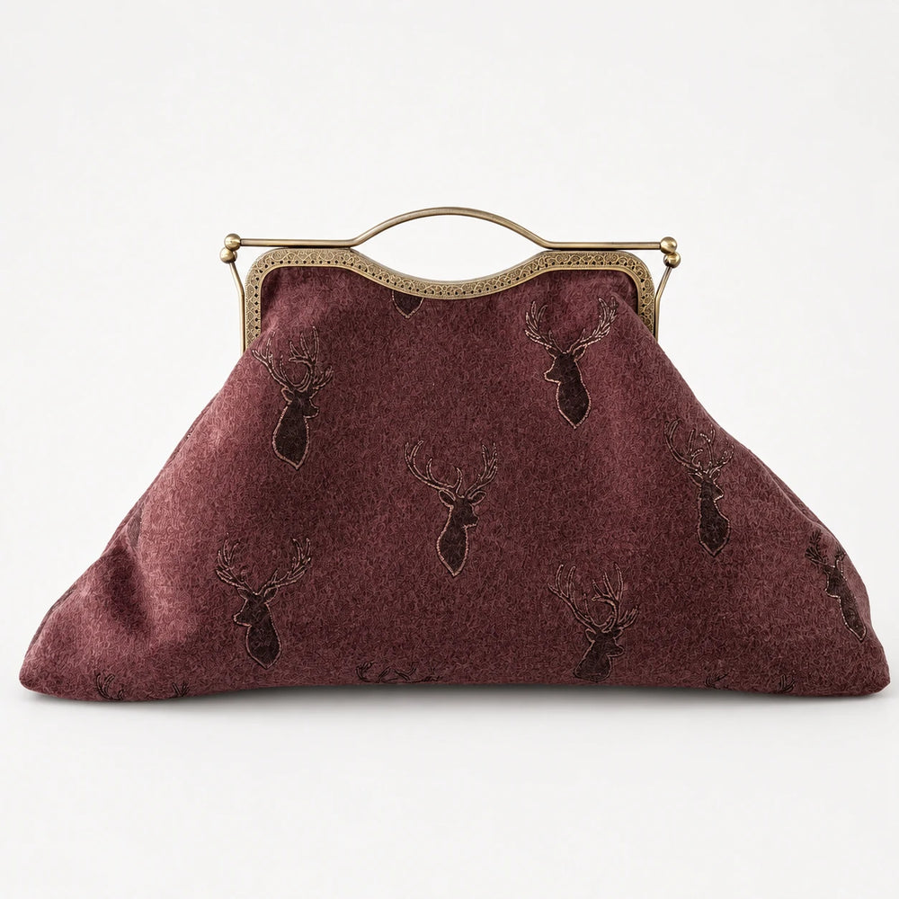 Brown textured handbag with deer head design and gold frame on a white background