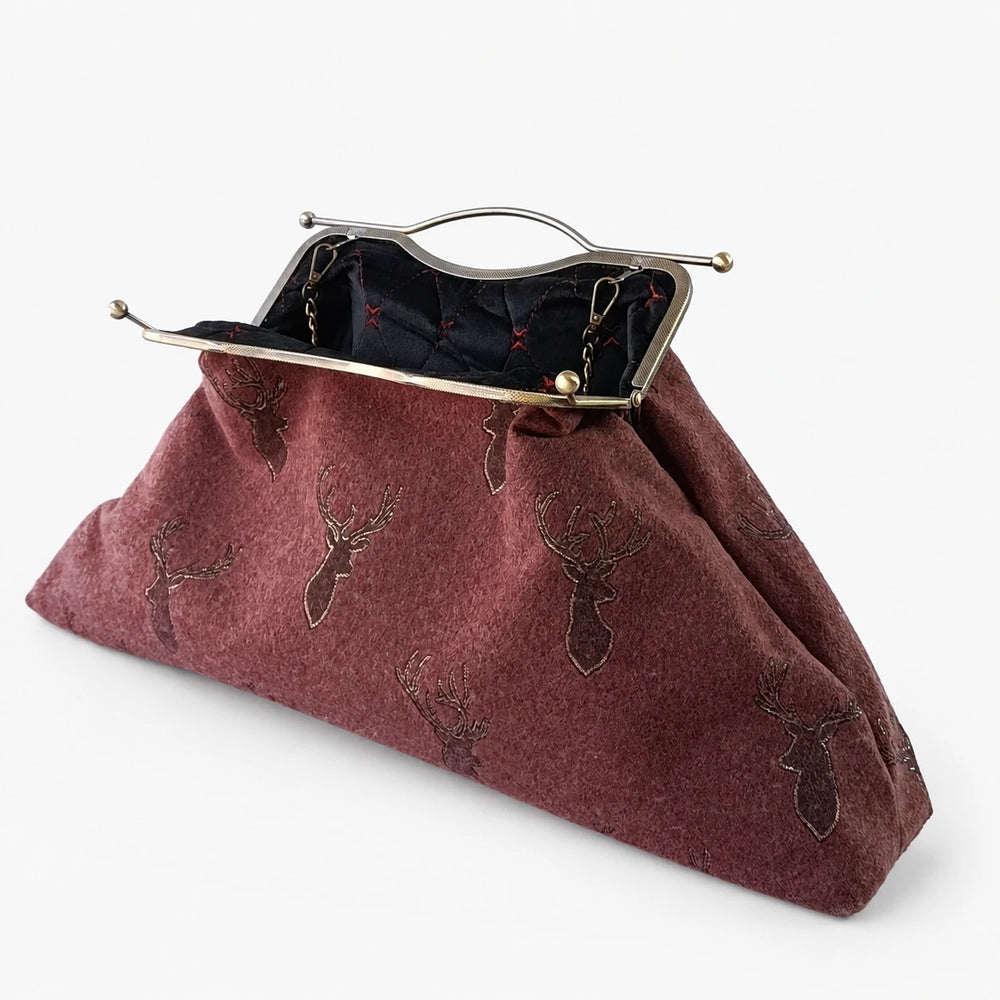 Maroon clutch bag with deer embroidery on a white background