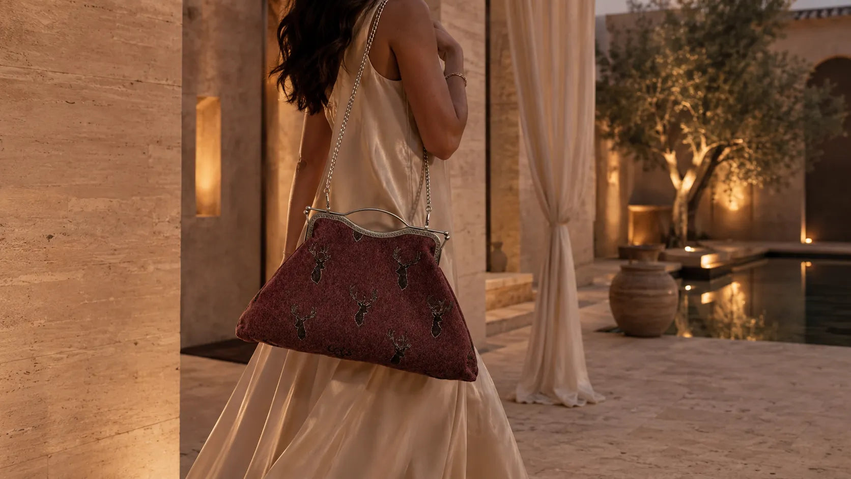 Woman holding a red handbag in an outdoor setting with warm lighting