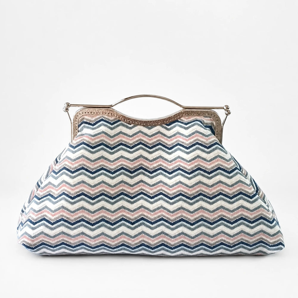 Zigzag patterned handbag with a metallic frame on a white background