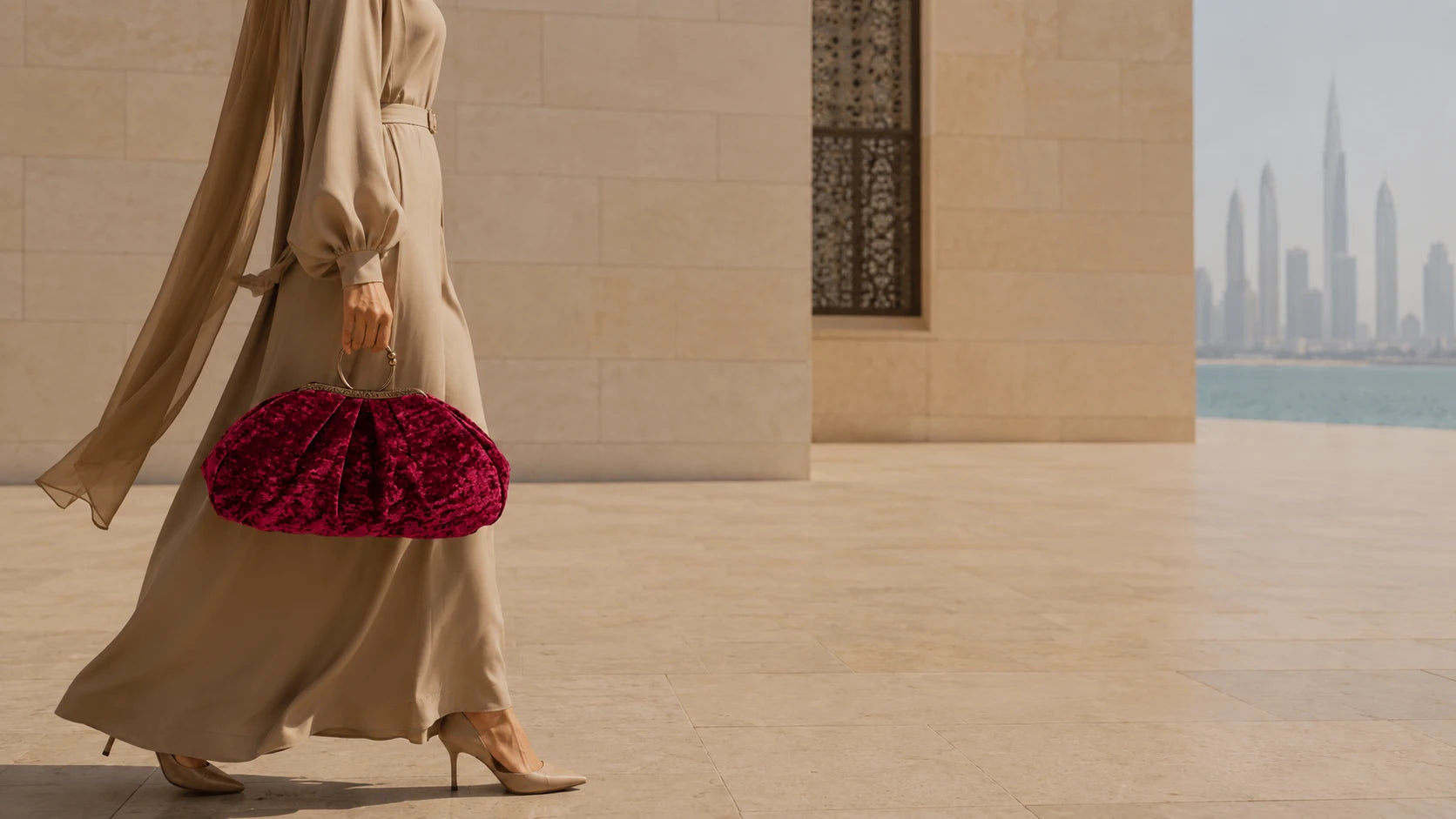 Person holding a red clutch bag with a cityscape in the background