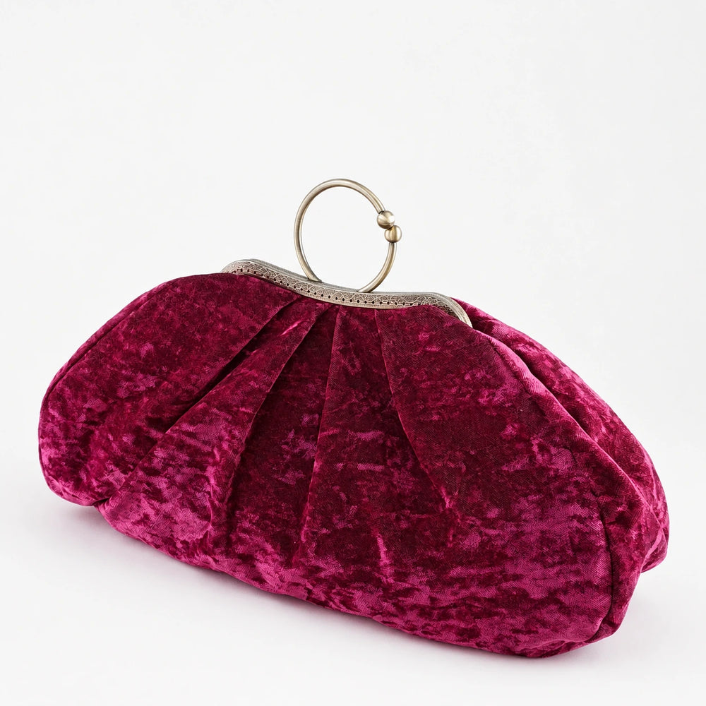 Pink velvet clutch bag with a gold clasp on a white background