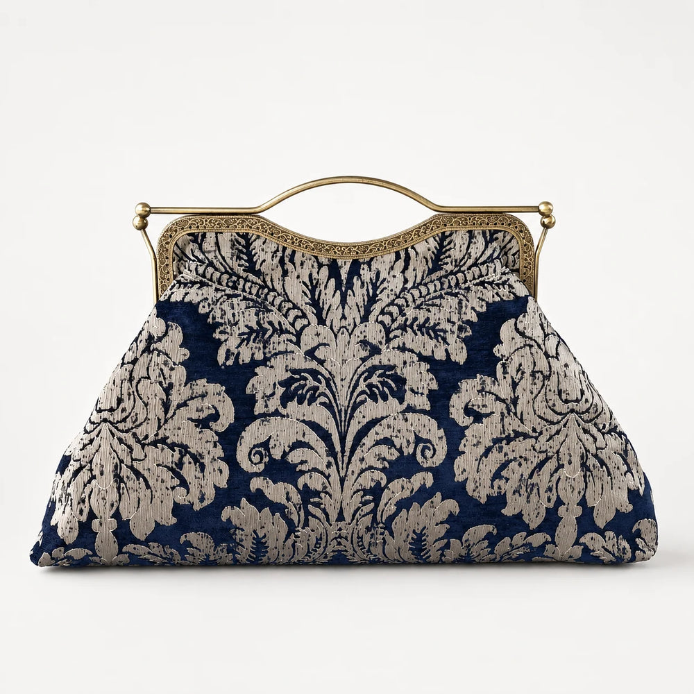 Navy and beige floral patterned handbag with gold frame on a white background