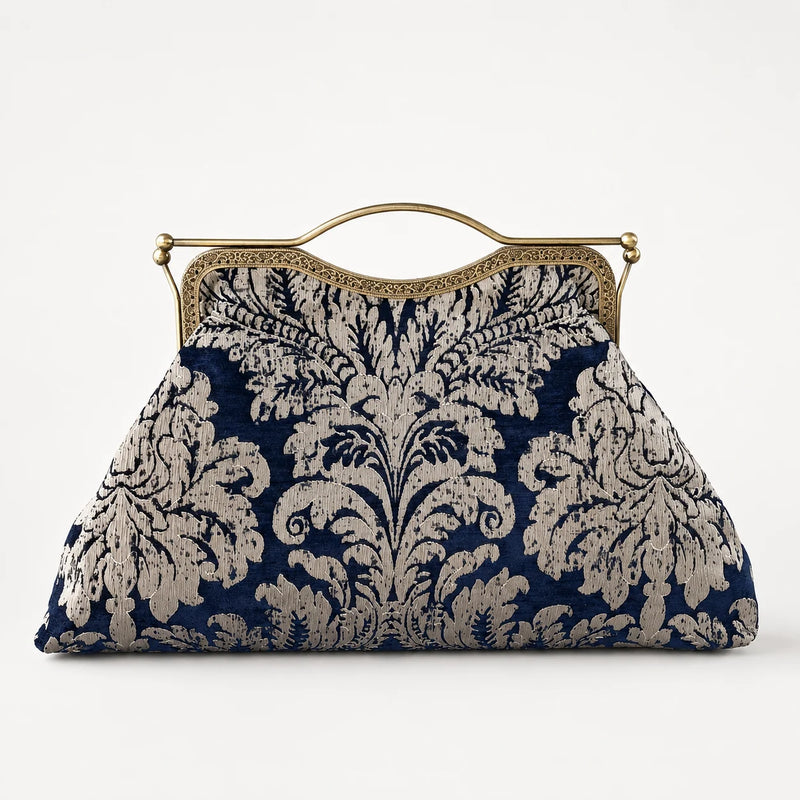 Navy and beige floral patterned handbag with gold frame on a white background