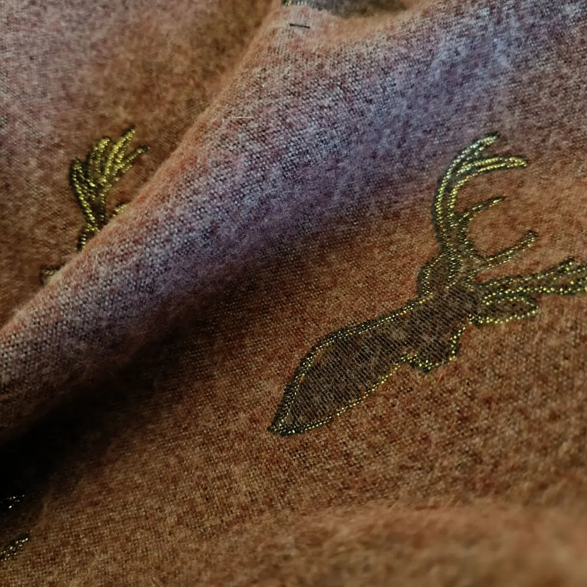 Close-up of embroidered deer on fabric with a soft focus background