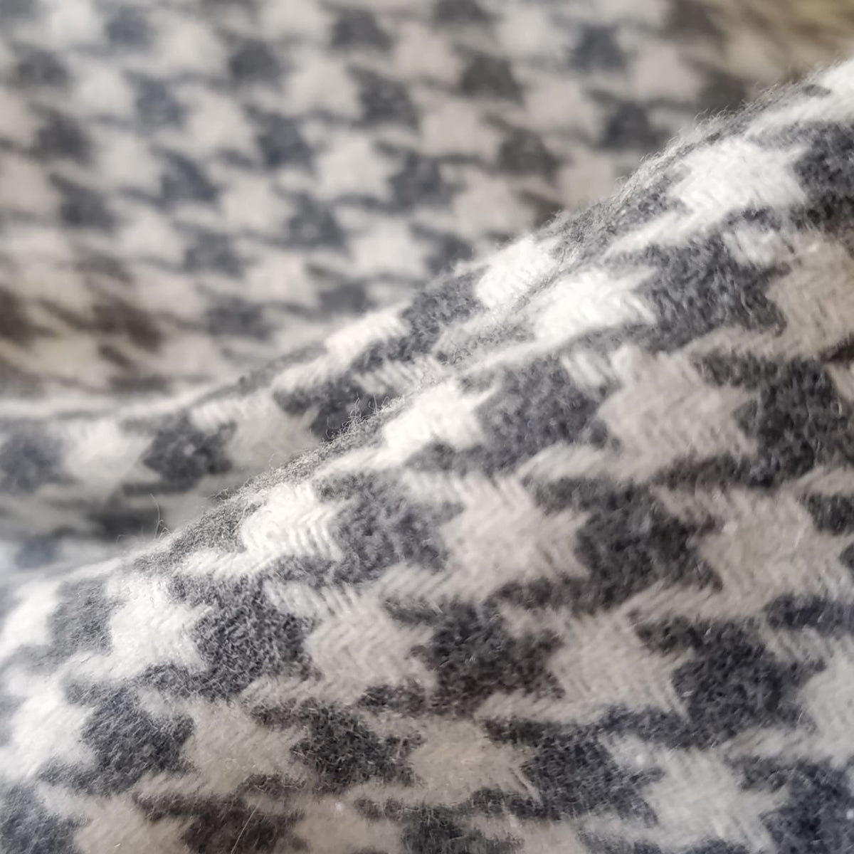Close-up of a houndstooth pattern fabric in black and white.